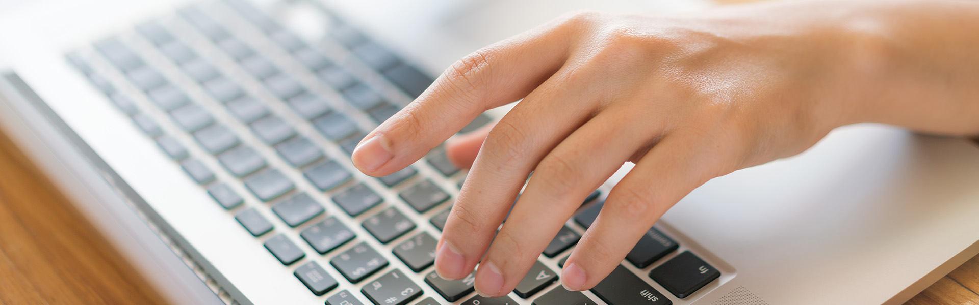 Hand tippt auf einer Laptoptastatur