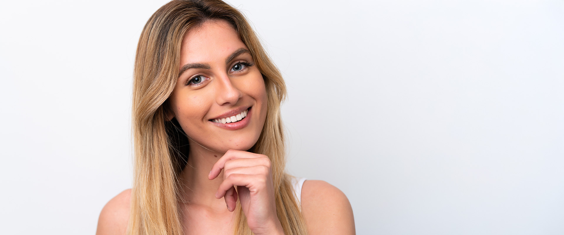 Frau hält ihre Hand fragend an ihr Kinn