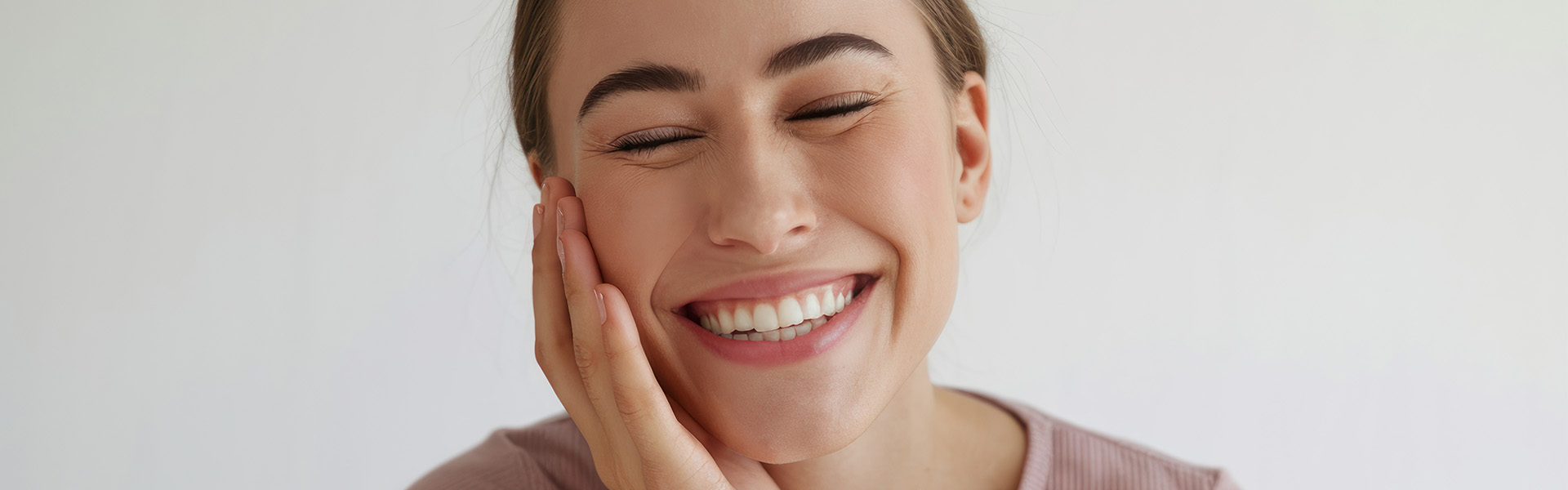 Frau zeigt lächelnd ihre geraden Zähne